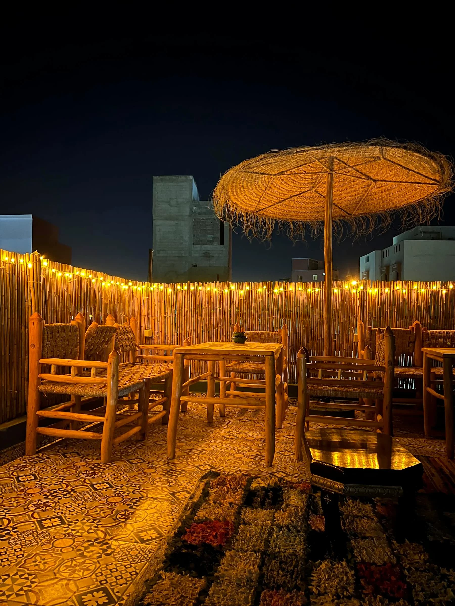 The rooftop at night, string lights on