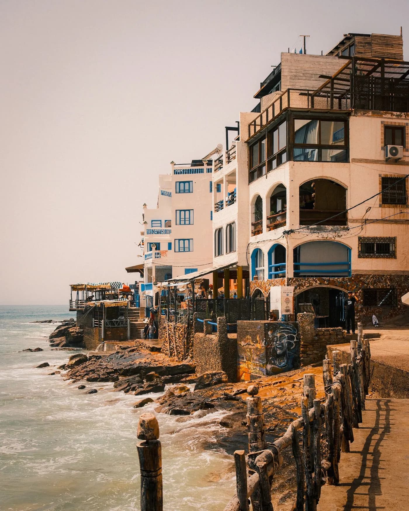 Taghazout's blue-shuttered seafront houses above the rocks