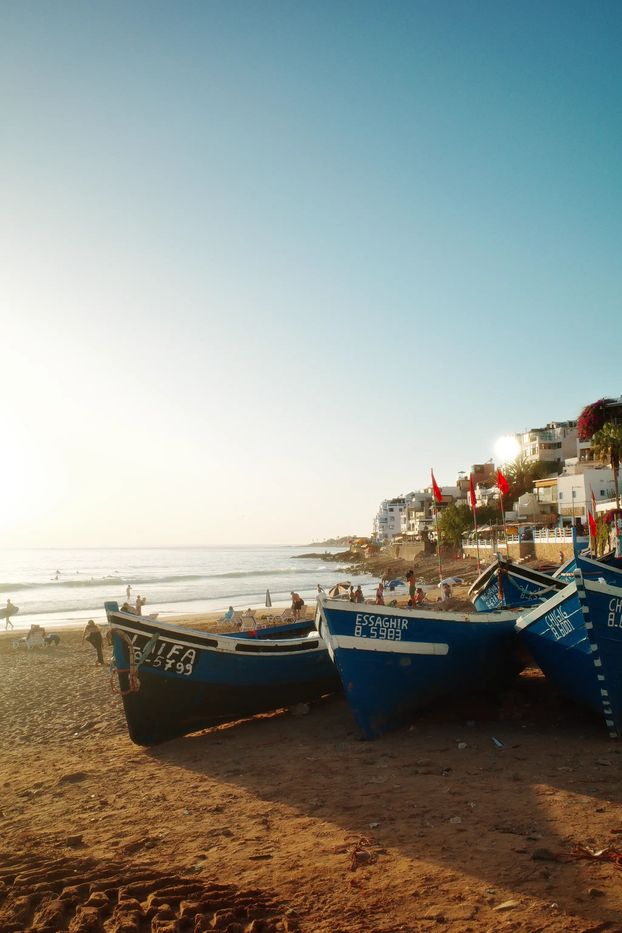 Blue fishing boats on Taghazout beach at golden hour