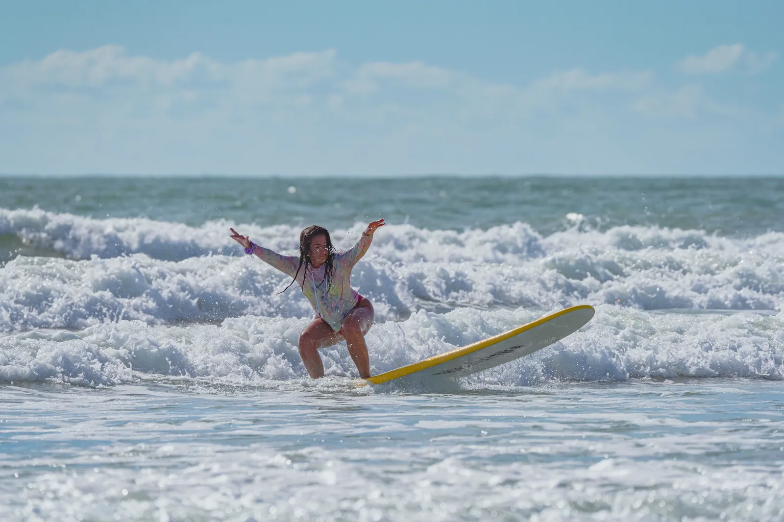 A guest popping up on her first waves in the whitewater