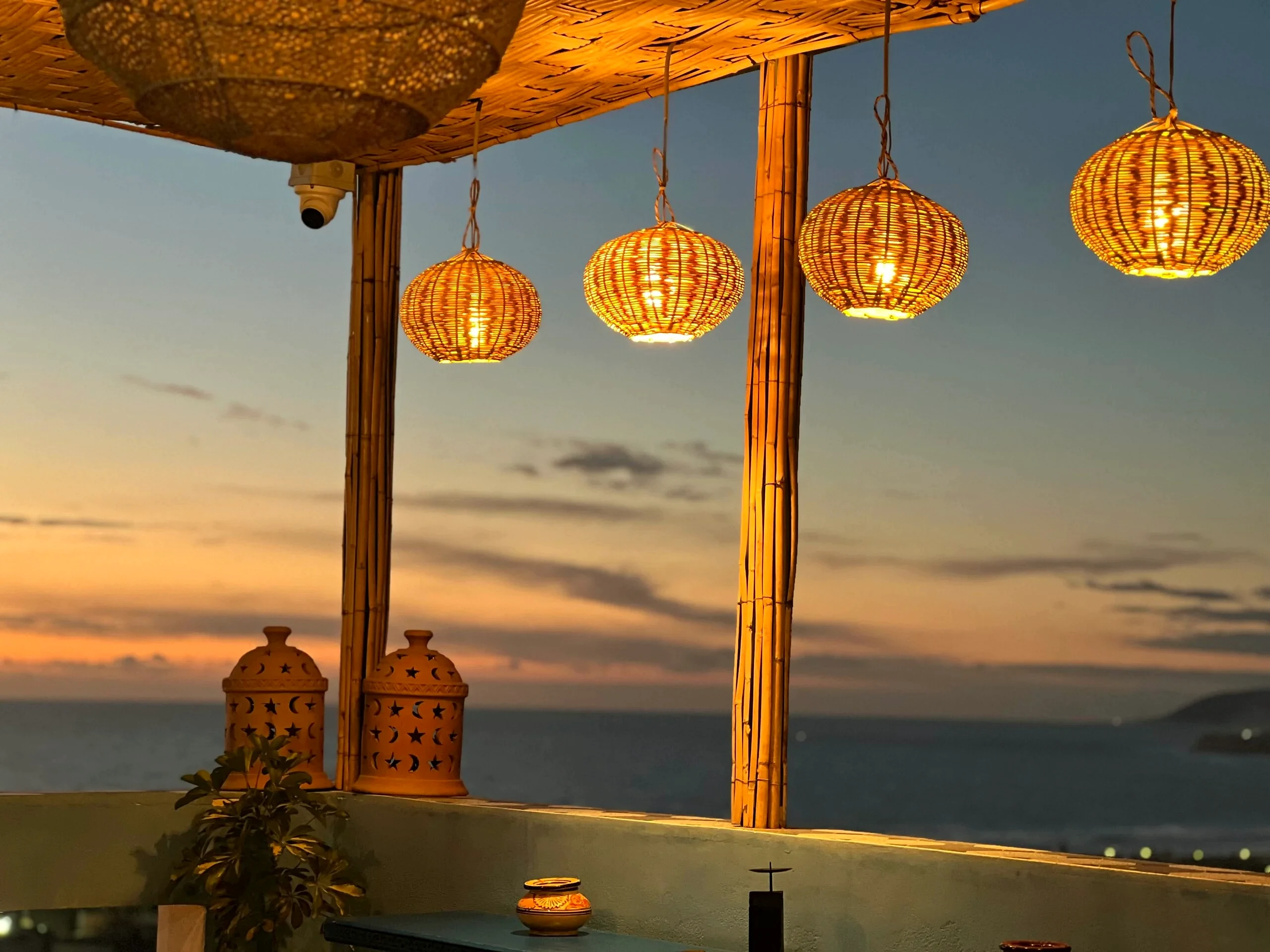 Golden-hour lanterns on the Blue Pearl rooftop over the Atlantic