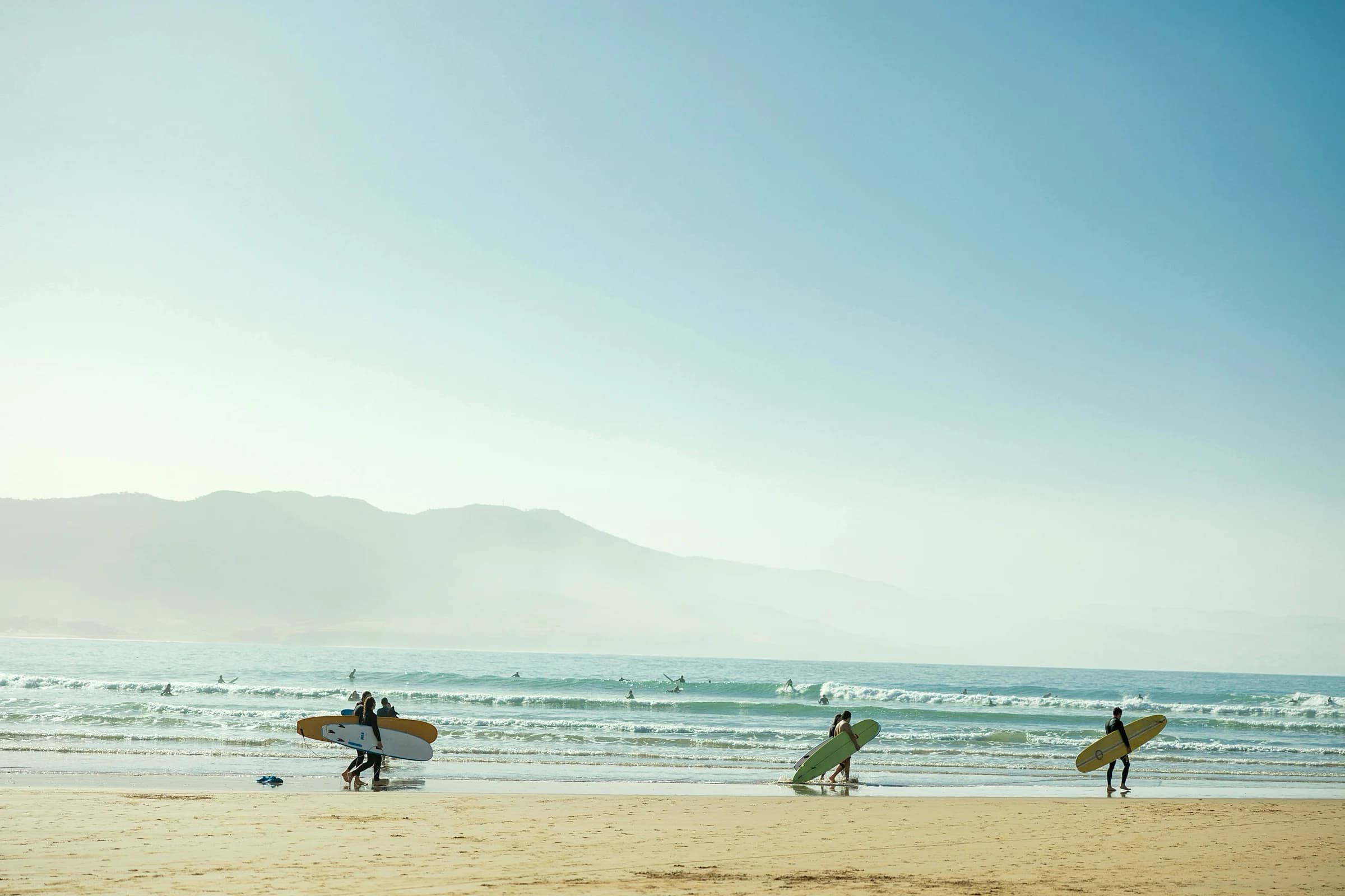 Walking the beach with boards at first light